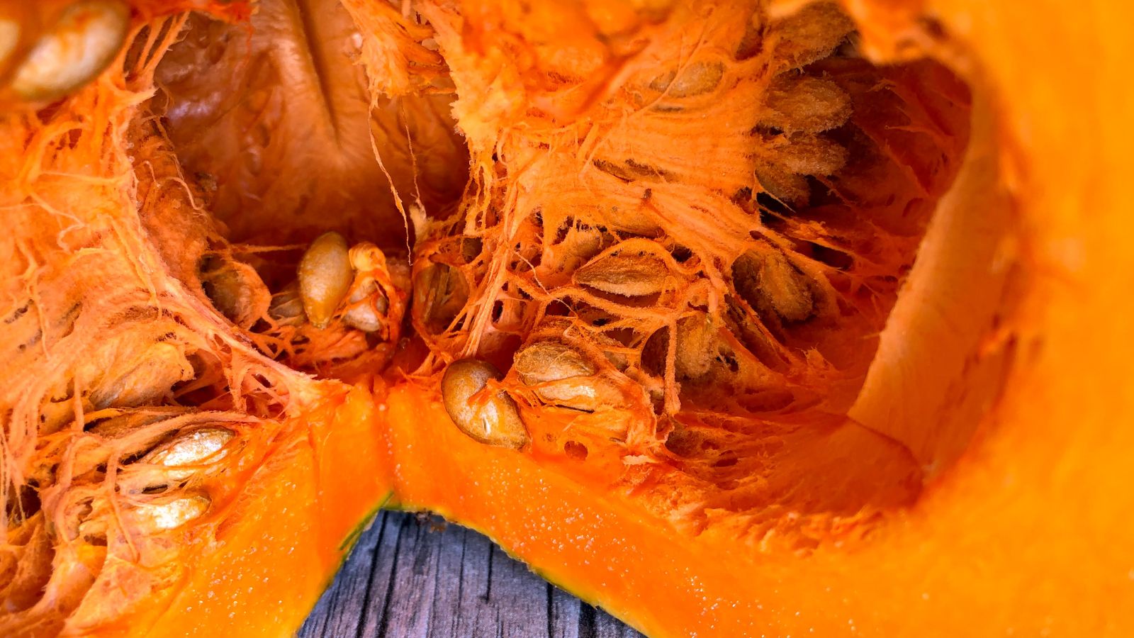 A round crop sliced to reveal multiple pits still caked the crop's insides, appearing to have a bright and vibrant orange hue