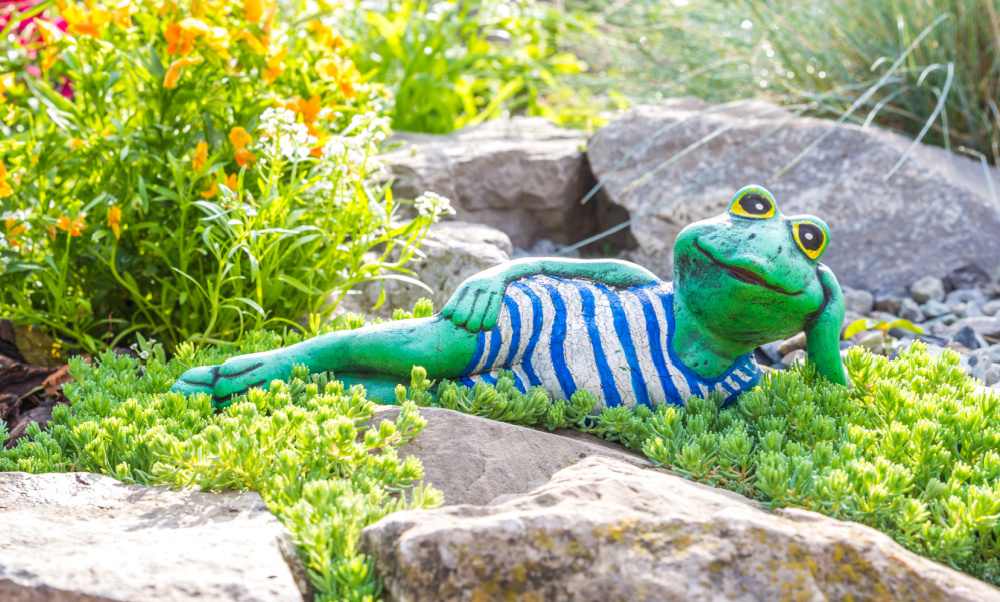 Painted statue of a frog lying in the sun.