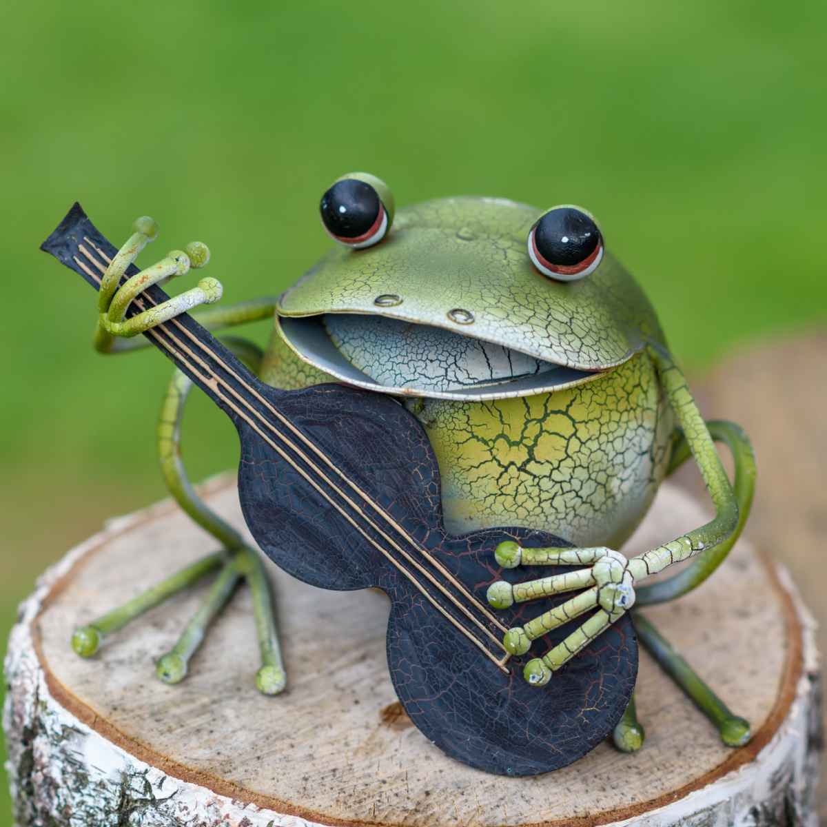 Frog Garden Decor: Metal frog playing a banjo on a garden stump.