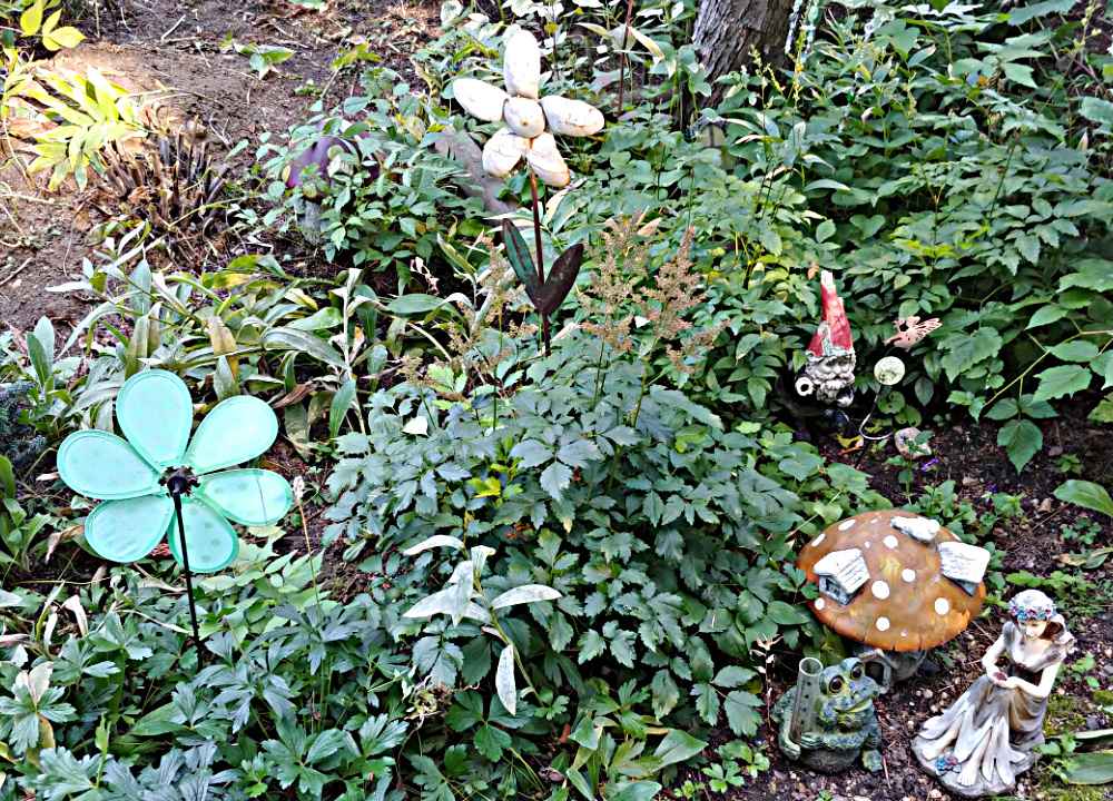 Fairy garden at Tizer Botanic Gardens with gnomes and metal flowers.