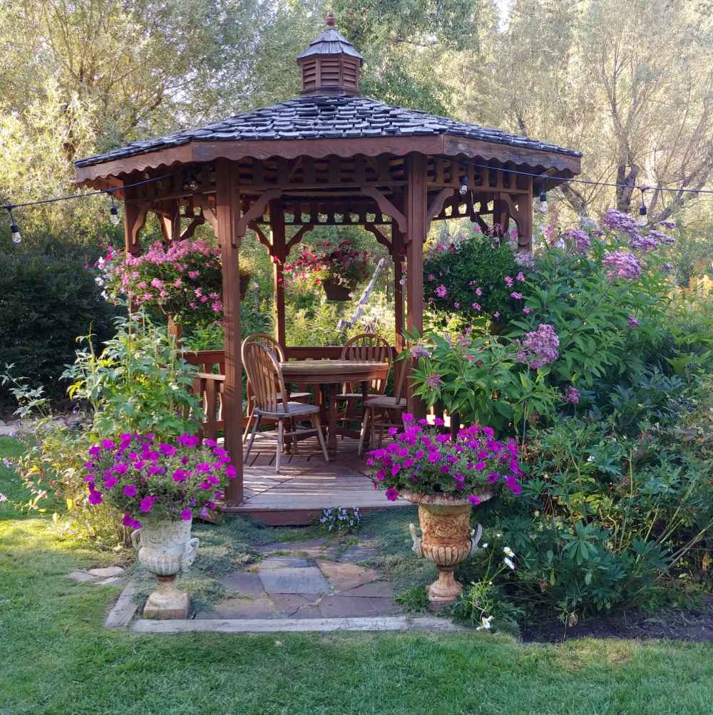 Pretty gazebo with flowers and shrubs nearby.