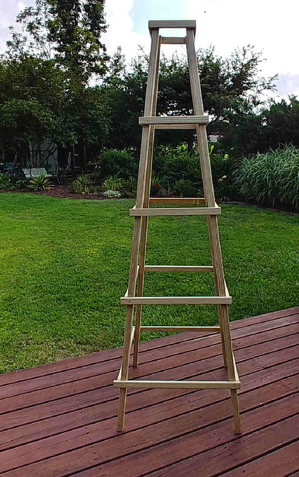 Wooden garden obelisk on a deck.