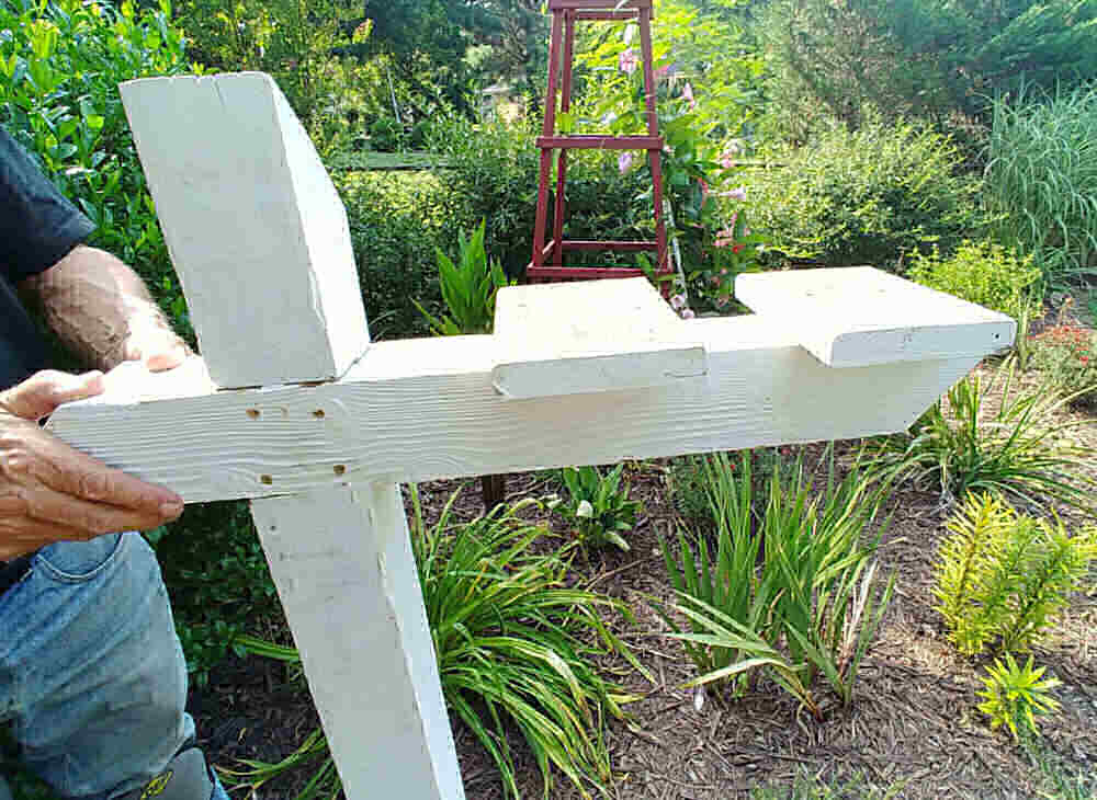 Finished mailbox post with hands holding it.