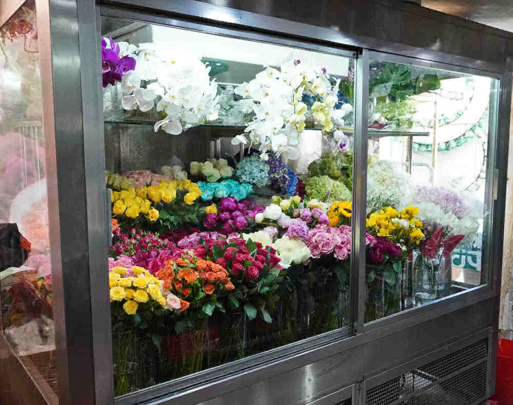 Fresh flowers in an upright cooler.