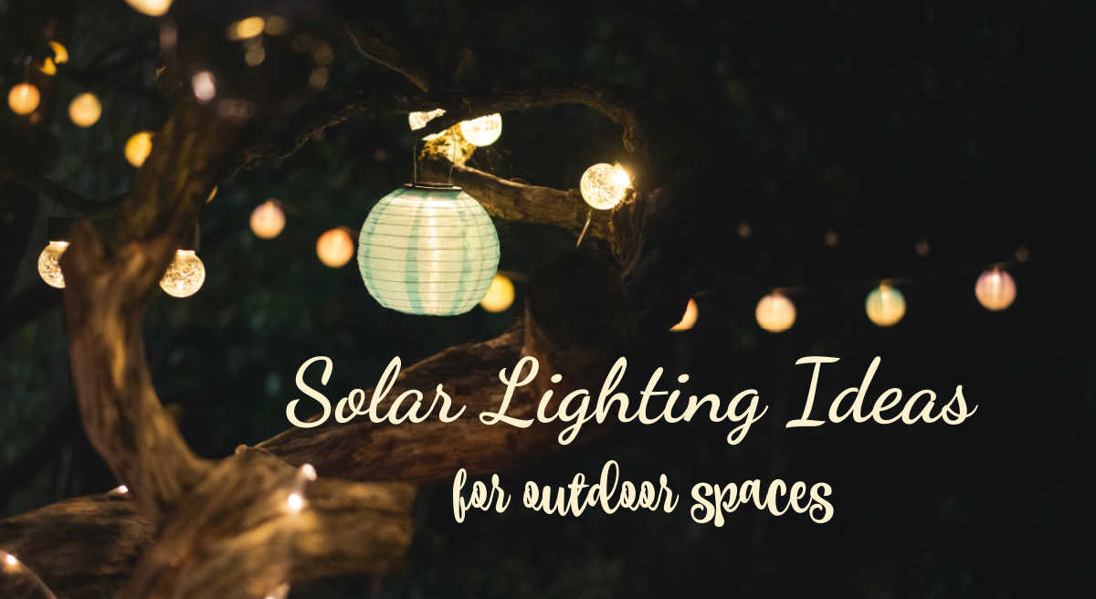 Solar powered lanterns in a tree in a garden at night with words Solar Lighting Ideas for outdoor spaces.